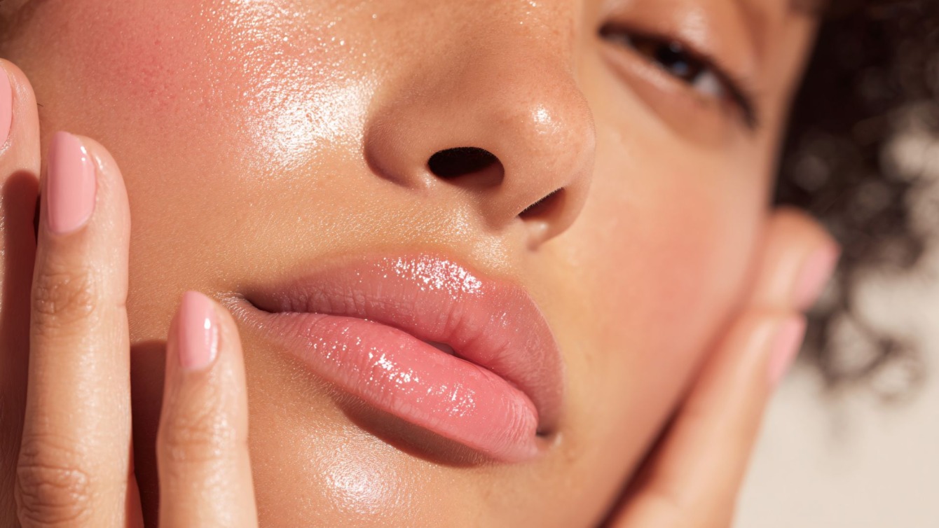 Her er et forslag til en ALT-tekst på dansk: Et nærbillede af en kvindes ansigt, der fremhæver utrolig glødende, velplejet hud og fyldige, blanke læber. Billedet illustrerer de naturlige resultater, man kan opnå hos Cerix med behandlinger som skinbooster til ansigtet eller filler til læberne for fugt og volumen.